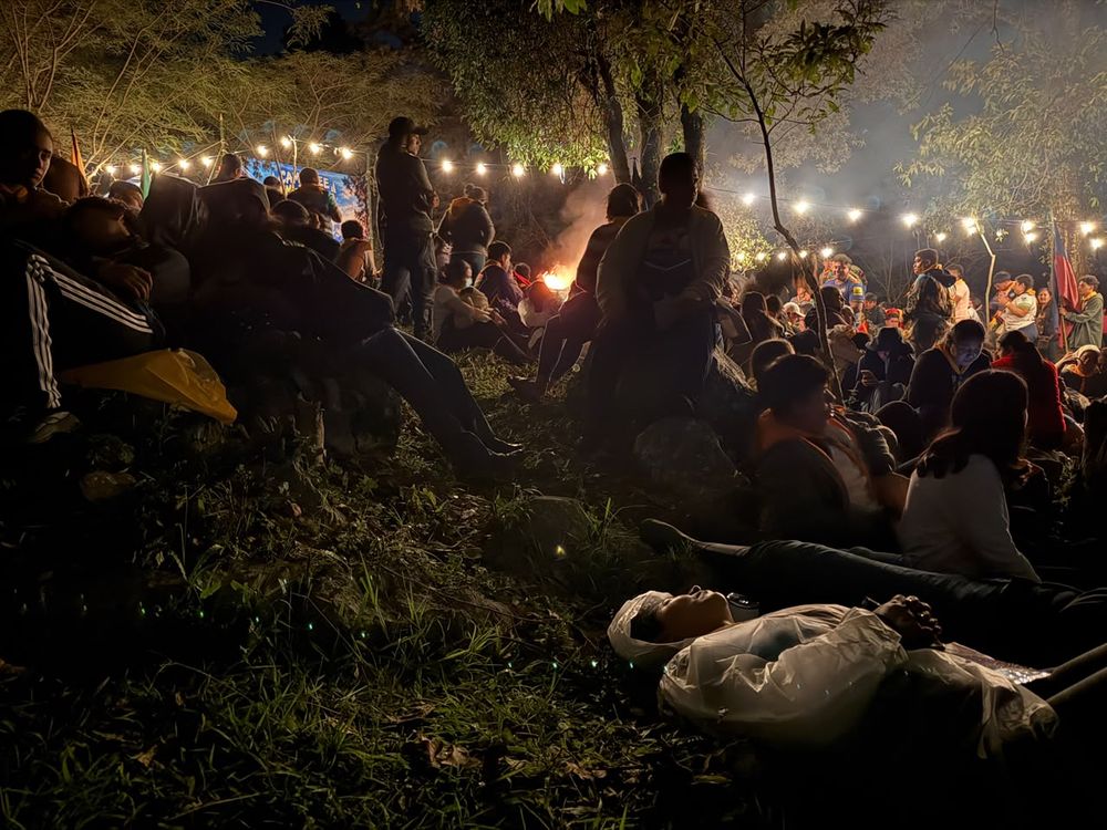 Noche de fogata con luces en el campamento